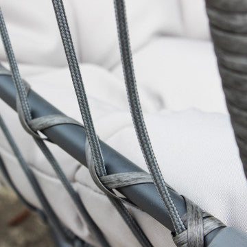 Klappschaukel mit grauem Metallgestell und Sitzfläche aus Aluminiumseilen Ø 6,5 mm, passendes Polyesterkissen. Gestell Ø 95 x 196h, Sitzfläche 73 x 64 x 108.